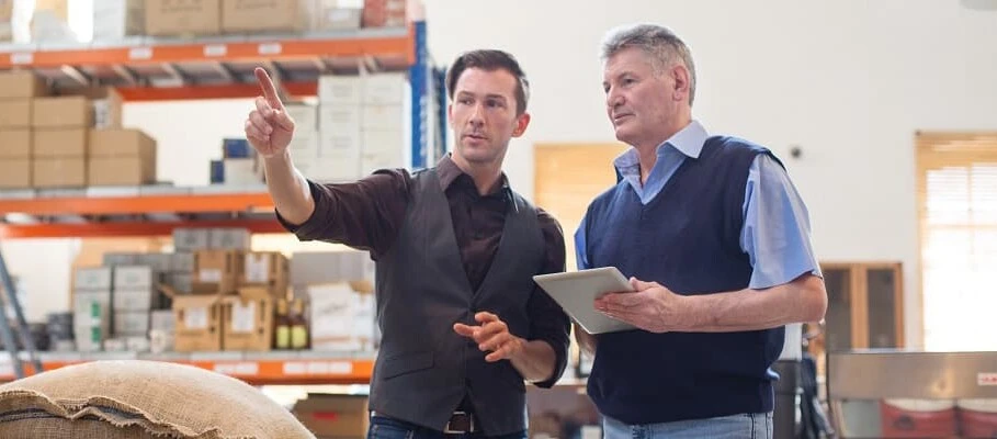 Warehouse managers reviewing stock levels and inventory processes in an industrial storage facility