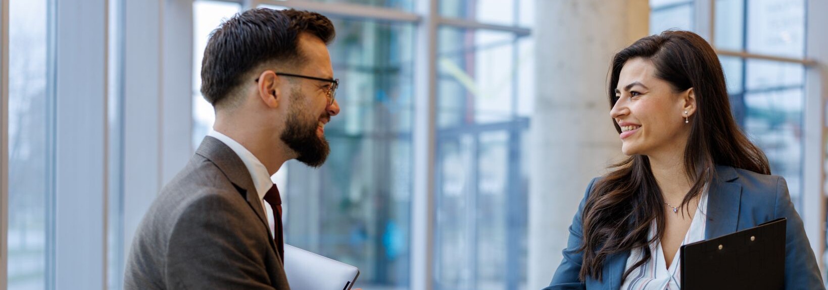 Business professionals shaking hands in a modern office, symbolising a B2B partnership.