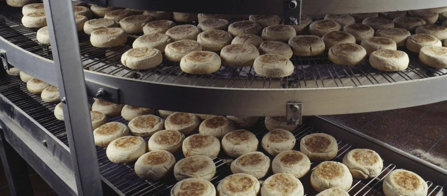 Industrial food production line with baked products circulating through a large commercial oven
