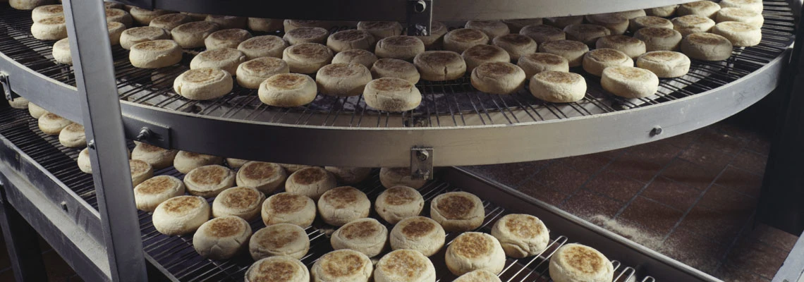 Industrial food production line with baked products circulating through a large commercial oven